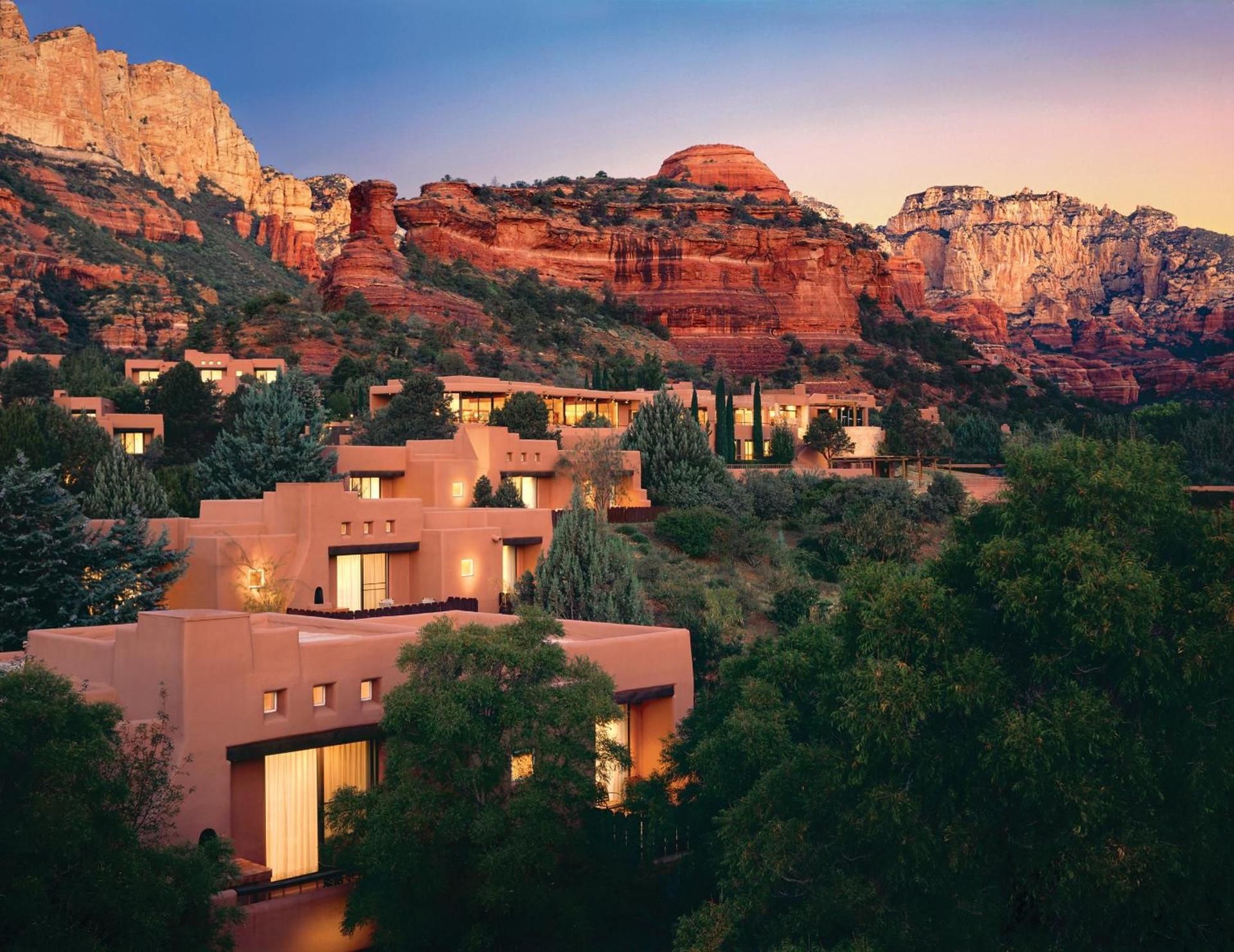 Adobe casitas of Enchantment Resort glowing at dusk beneath the red rock cliffs of Boynton Canyon in Sedona, Arizona